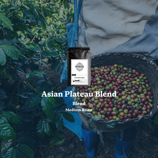 Bag of Asian Plateau Blend coffee with coffee cherries and coffee plant in the background