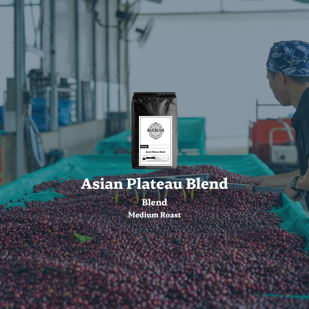 Coffee beans with a coffee bag labeled Asian Plateau Blend in a processing plant