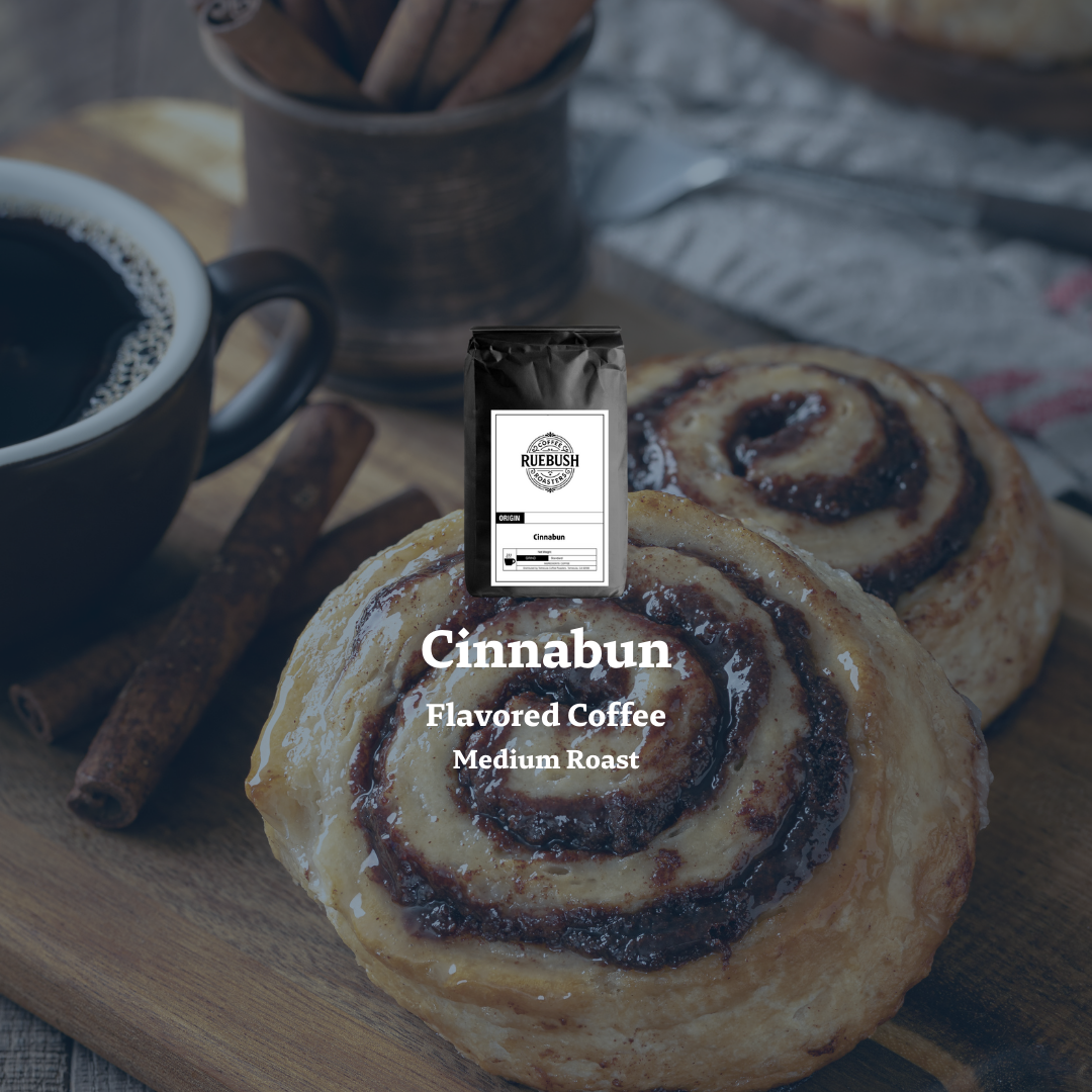 Cinnabun flavored coffee package with cinnamon rolls and a cup of coffee on a wooden surface