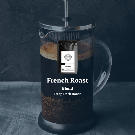French press with a bag of coffee labeled French Roast Blend Deep Dark Roast on a dark background