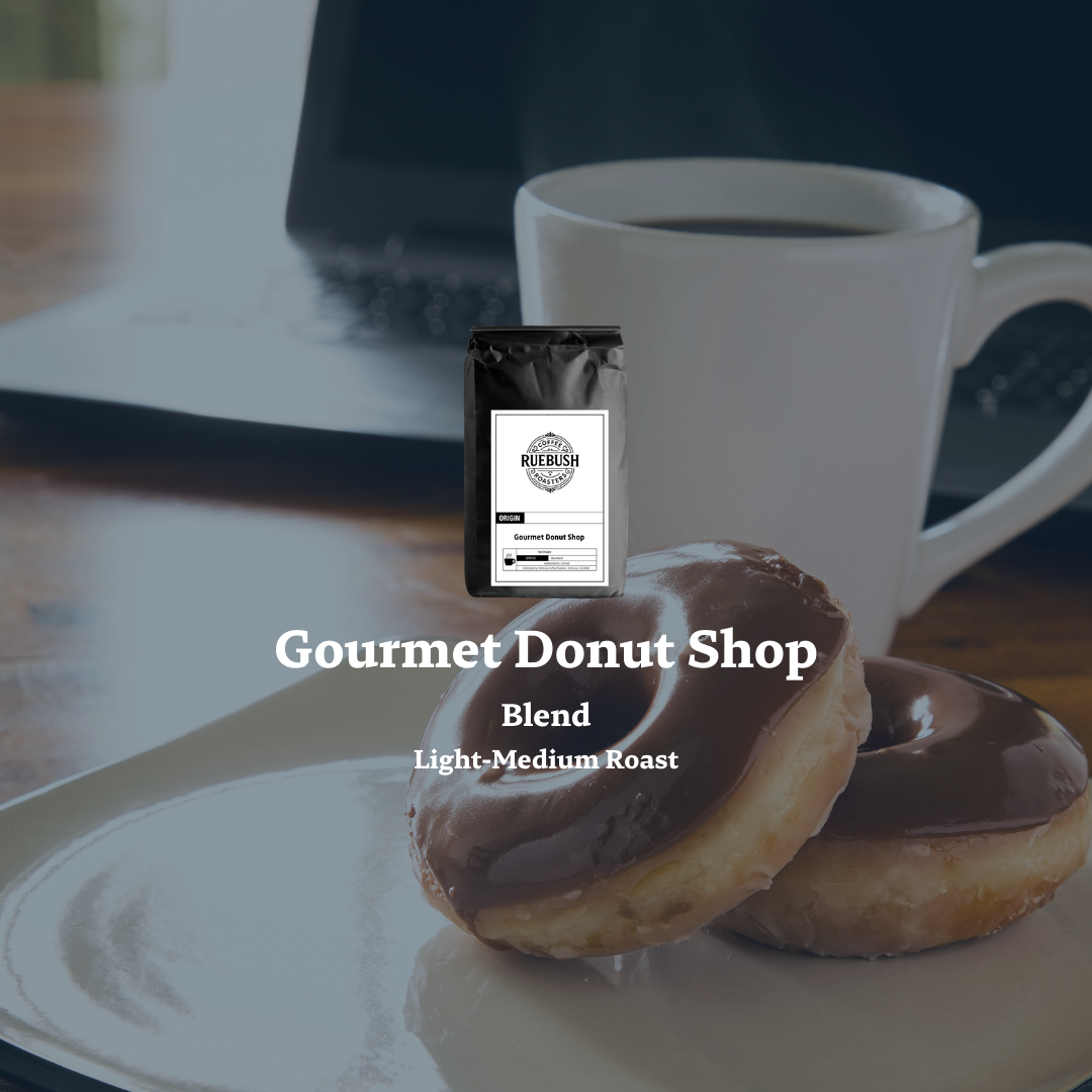 Chocolate-glazed donuts on a plate with a coffee cup and Gourmet Donut Shop coffee bag by Ruebush Coffee Roasters in the background.