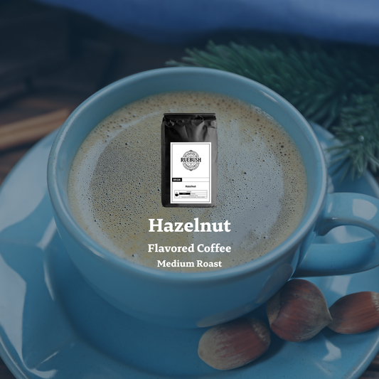 Blue mug with hazelnut flavored coffee on a saucer with coffee beans and greenery
