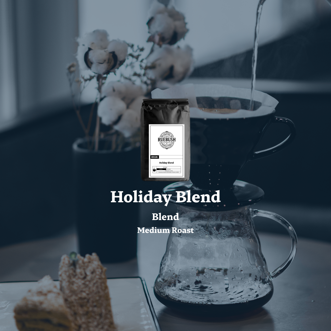 Coffee bag labeled Holiday Blend with a coffee cup and pour-over setup on a blurred background