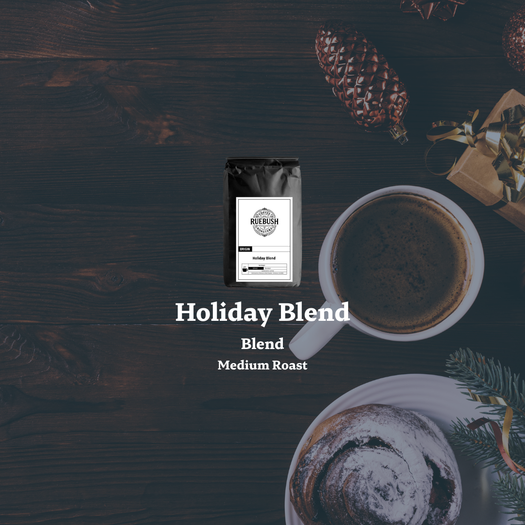 Holiday Blend coffee package with a cup of coffee on a dark wooden surface