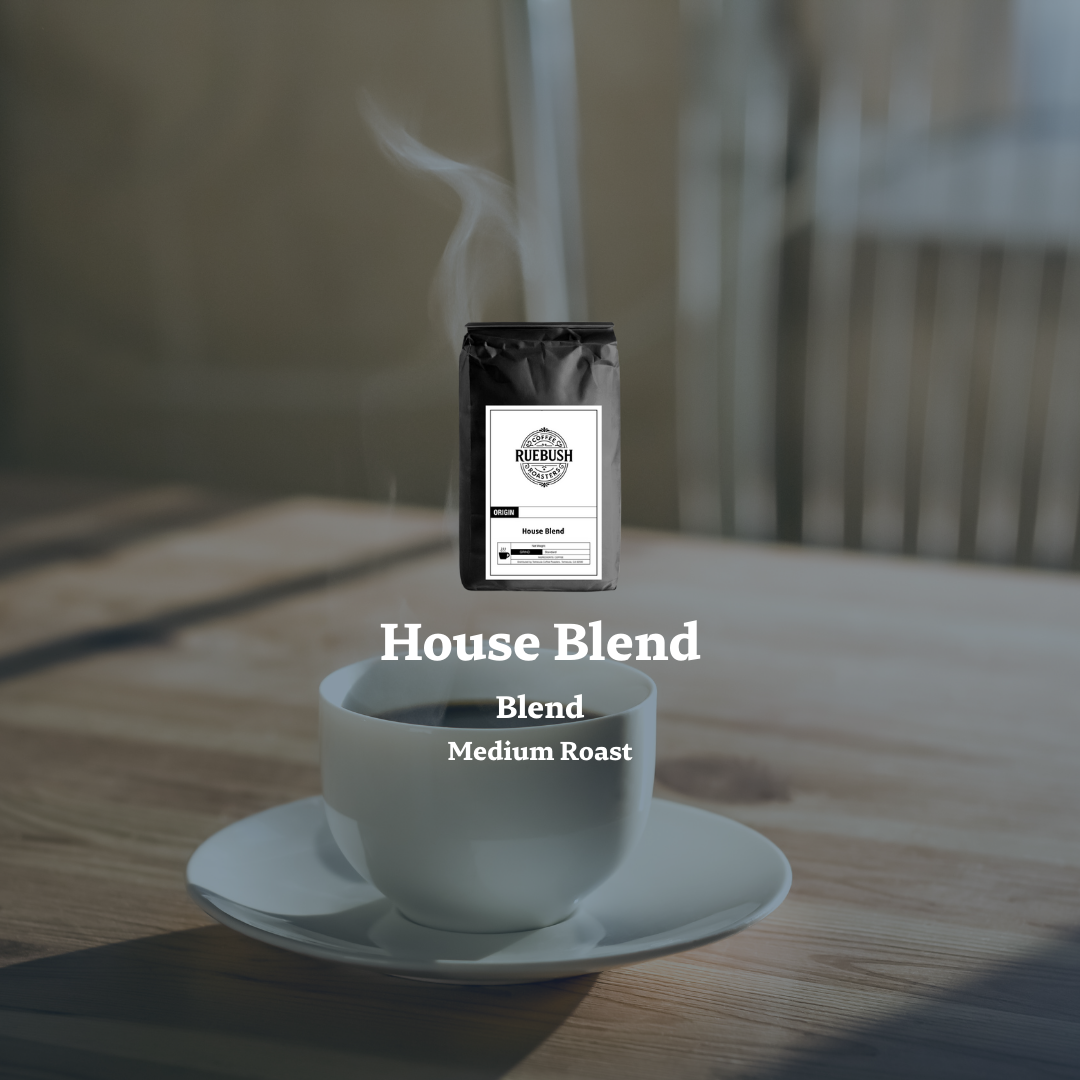 White cup and saucer with steaming coffee and a coffee bag labeled House Blend on a wooden surface