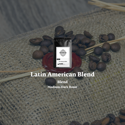 Coffee package labeled Latin American Blend surrounded by coffee beans on a textured surface