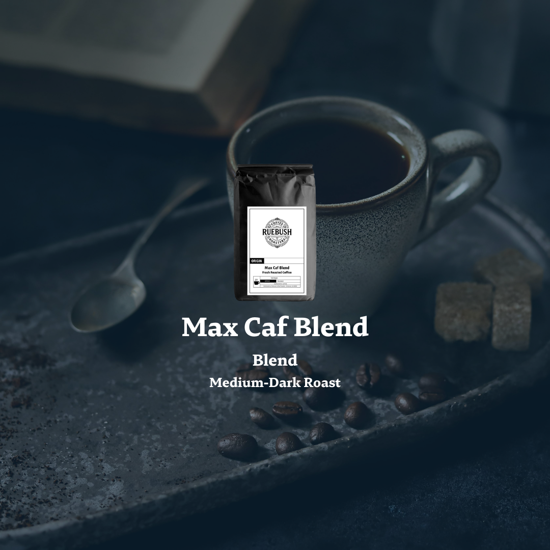 Coffee package labeled Max Caf Blend by Ruebush Coffee Roasters with a cup of coffee and coffee beans on a dark surface