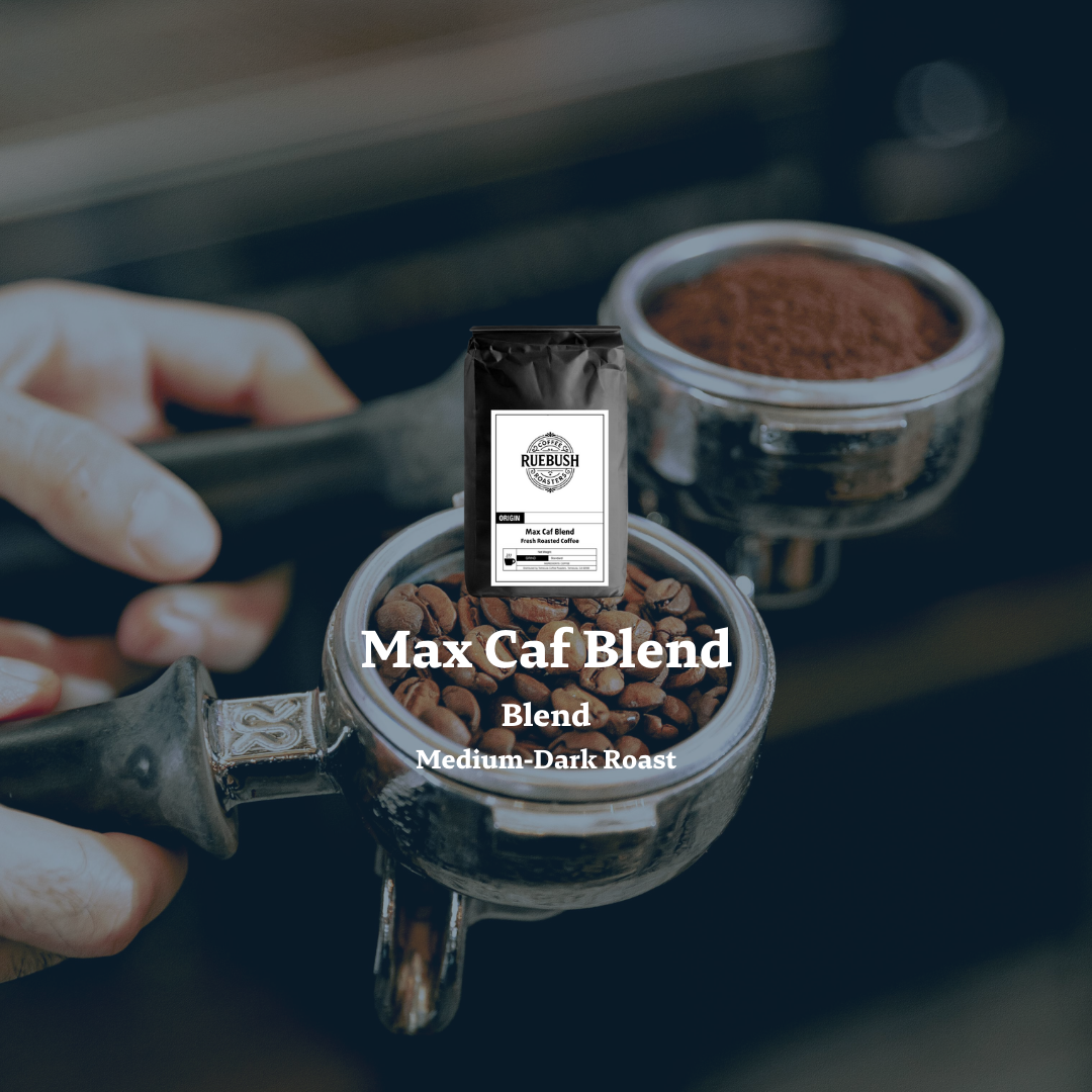 Coffee grinder with Max Caf Blend coffee by Ruebush Coffee Roasters and a bag of coffee on top, with a blurred background