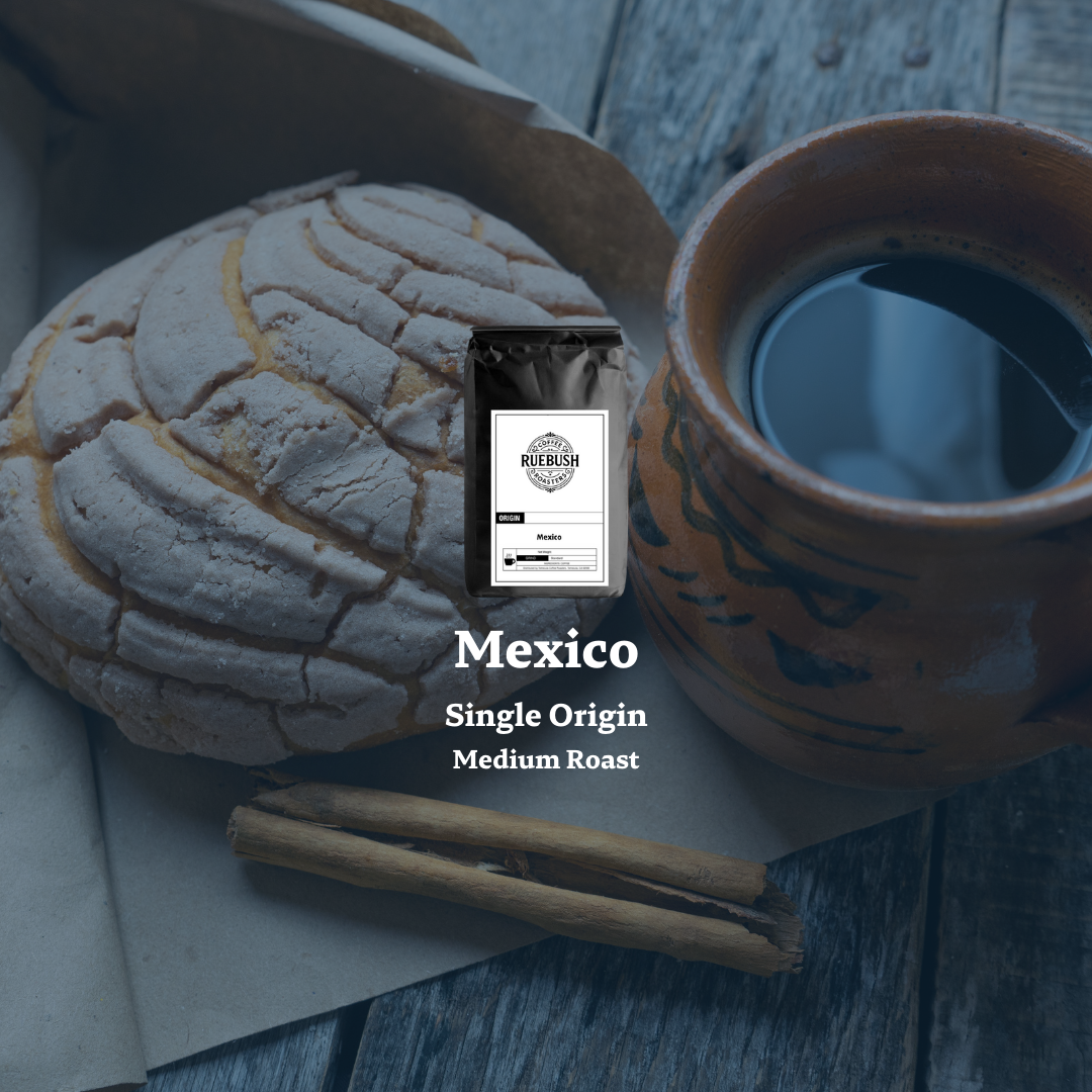 Coffee package labeled Mexico Single Origin Medium Roast with a cup of coffee and bread on a wooden surface