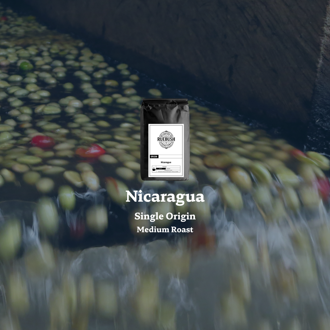 Coffee bag labeled Nicaragua Single Origin Medium Roast on a blurred background of coffee beans