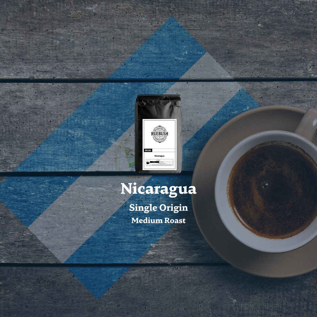 Coffee bag labeled Nicaragua Single Origin Medium Roast with a cup of coffee on a textured surface