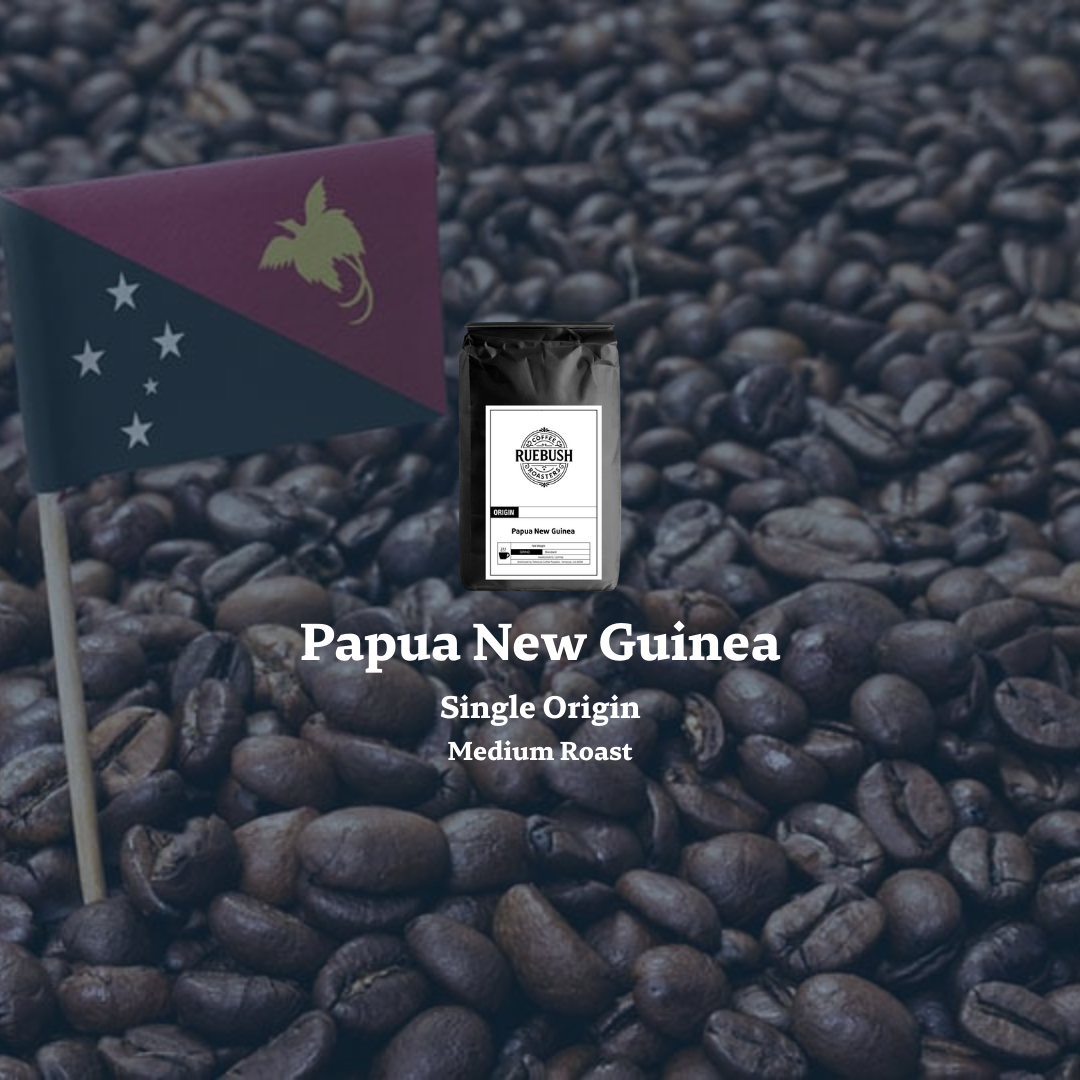 Coffee bag labeled Papua New Guinea Single Origin Medium Roast on a bed of coffee beans with a small flag