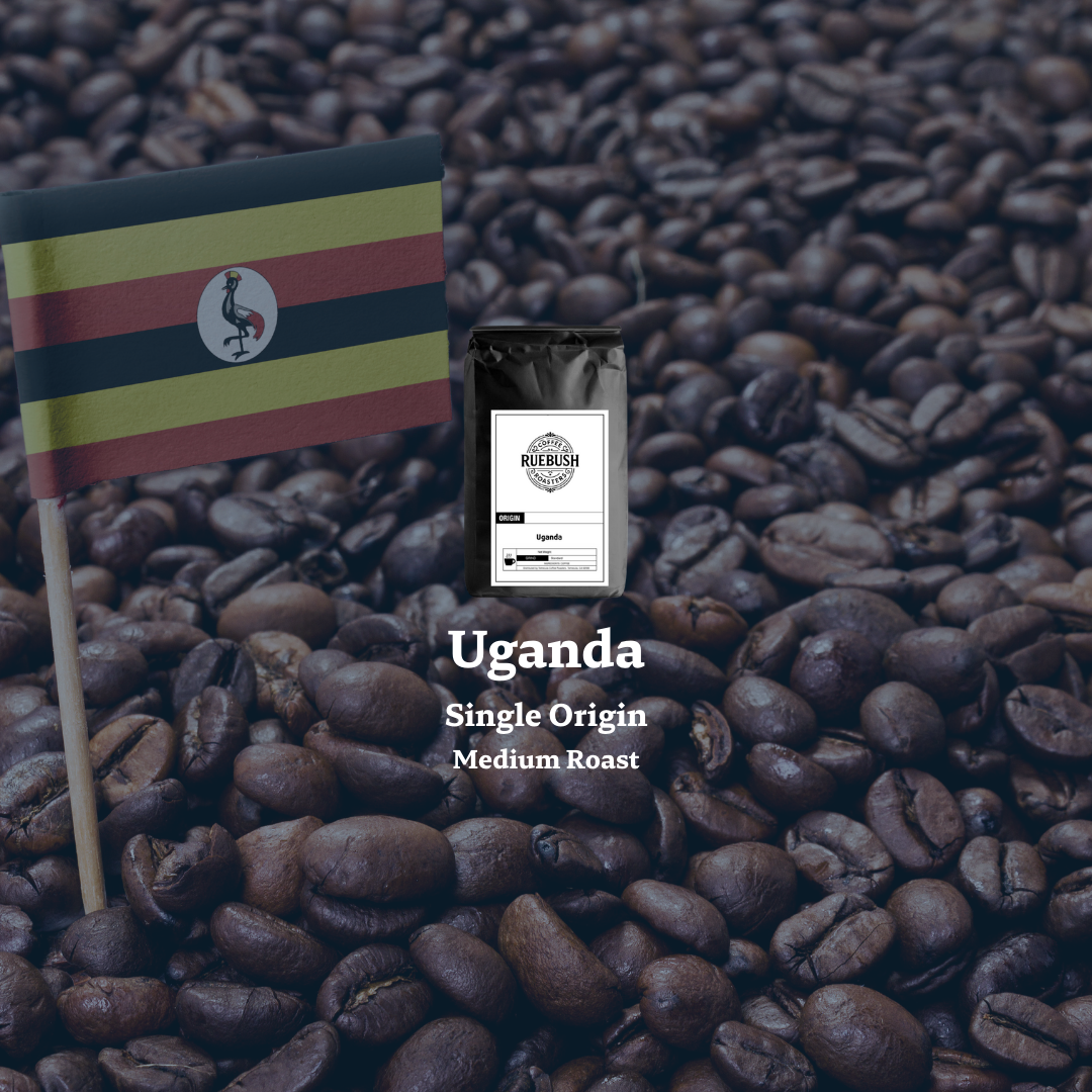 Coffee bag labeled Uganda Single Origin Medium Roast on a bed of coffee beans with an Uganda flag