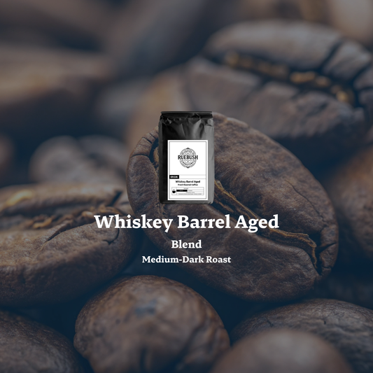 Coffee bag labeled Whiskey Barrel Aged Blend by Ruebush Coffee Roasters on roasted coffee beans