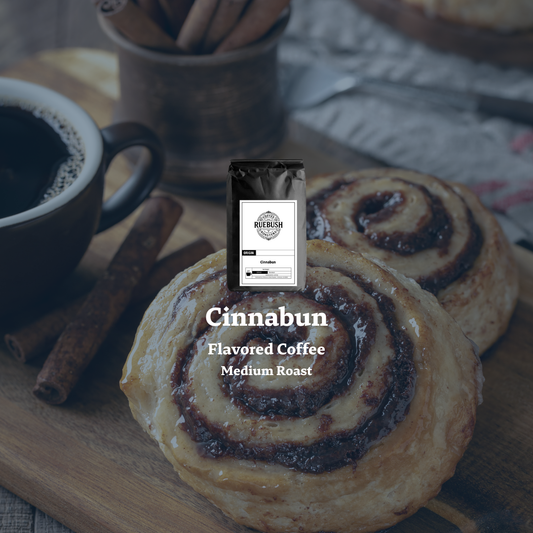 Cinnabun flavored coffee package with cinnamon rolls and a cup of coffee on a wooden surface