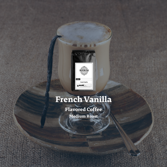 French Vanilla flavored coffee in a glass with a spoon on a textured surface