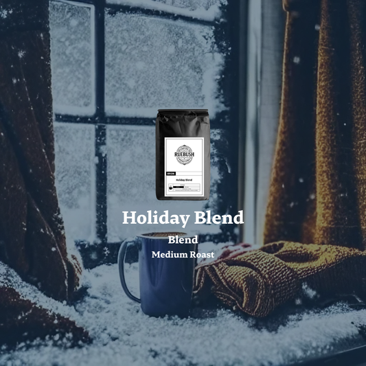 Coffee bag and mug labeled Holiday Blend by Ruebush Coffee Roasters in front of a snowy window