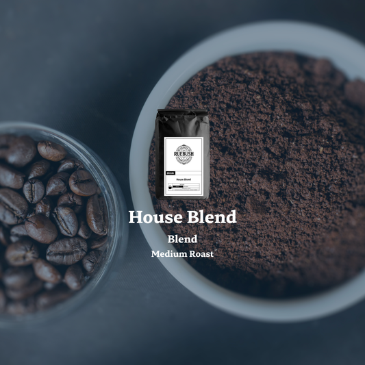 Coffee beans, ground coffee, and a package labeled House Blend by Ruebush Coffee Roasters on a dark background
