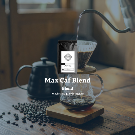 Max Caf Blend coffee packaging with a coffee filter and beans on a wooden table by Ruebush Coffee Roasters
