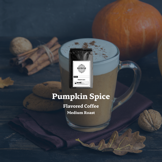 Pumpkin spice flavored coffee with a package labeled Ruebush Coffee Roasters on a dark surface with pumpkins and cinnamon sticks