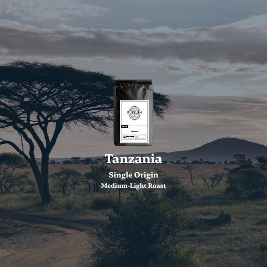 Coffee bag labeled Tanzania Single Origin Medium-Light Roast with a scenic background of a tree and open landscape.